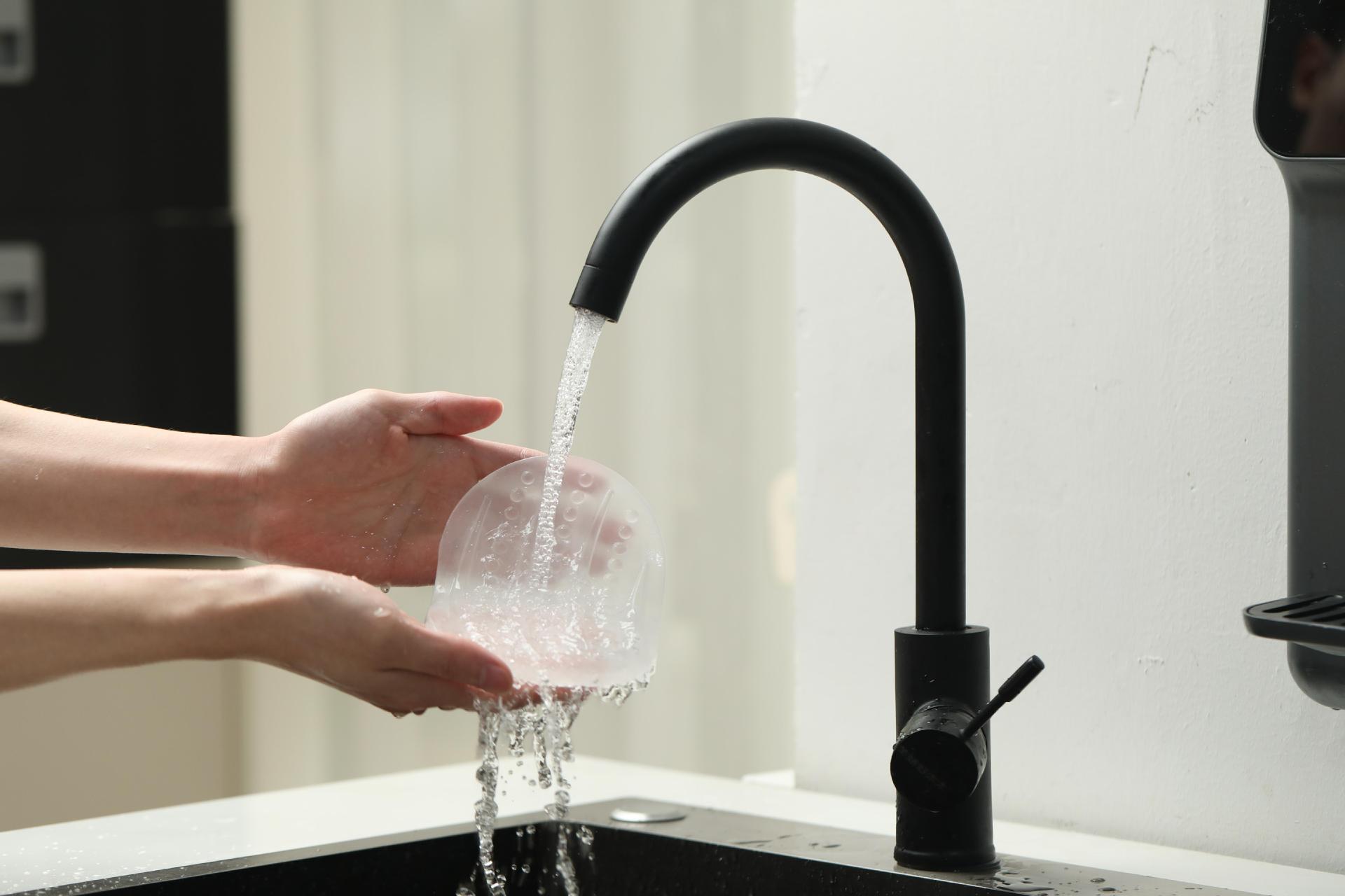 Rinsing the flexible male masturbator under clean water